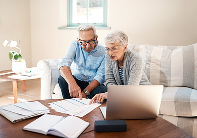 Buy stock photo Shot of a senior couple going through paperwork at home