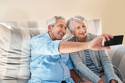 Buy stock photo Senior couple, selfie and smile on sofa with happiness on social media, blog or post on internet. Elderly man, woman and photography for profile picture on app, web or happy together on couch in home