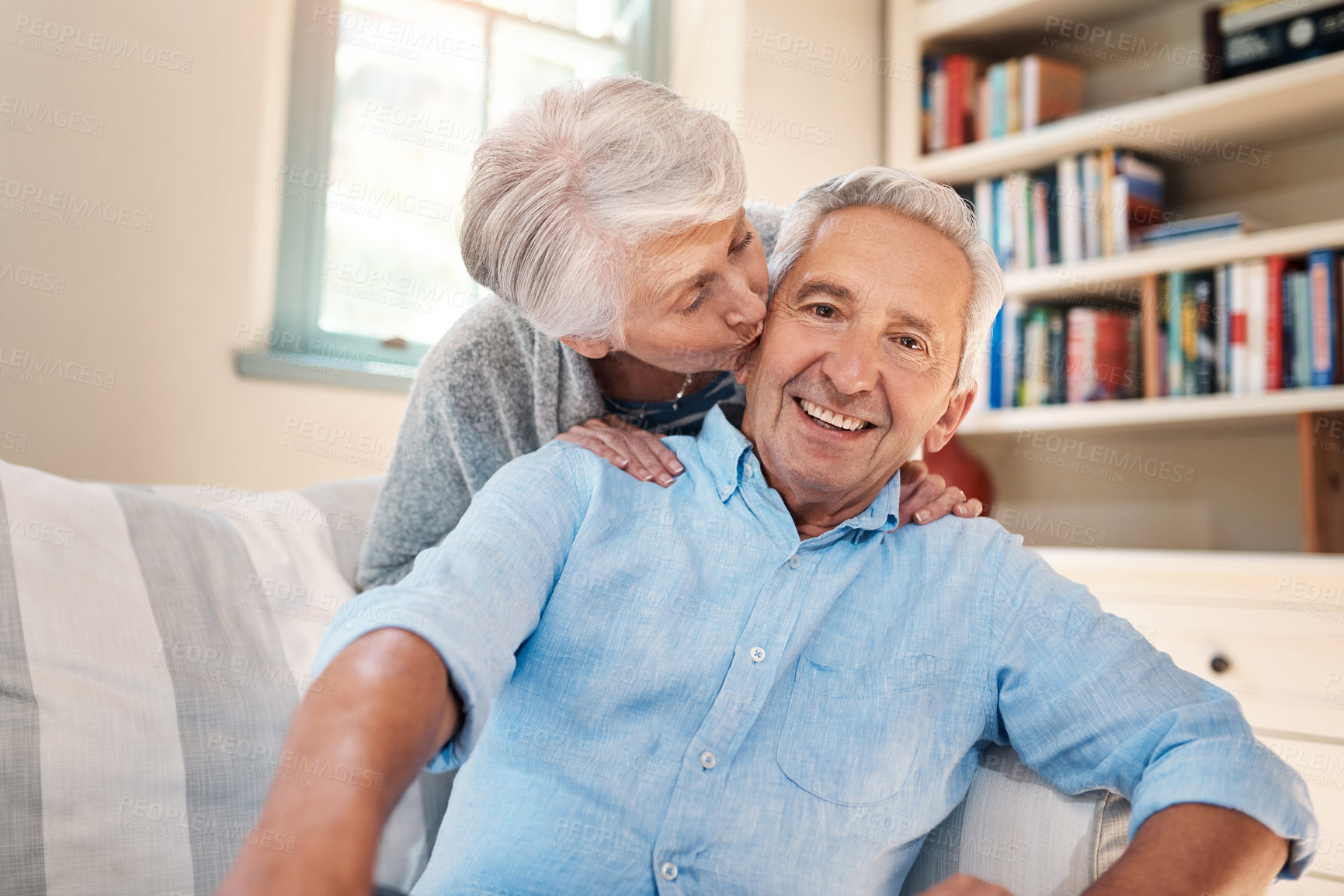 Buy stock photo Kiss, portrait and senior couple on sofa for connection, bonding and relaxing together at home. Happy, love and elderly man and woman hugging for resting in living room at house in Switzerland.