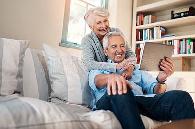 Buy stock photo Shot of a senior couple taking selfie together on the sofa at home