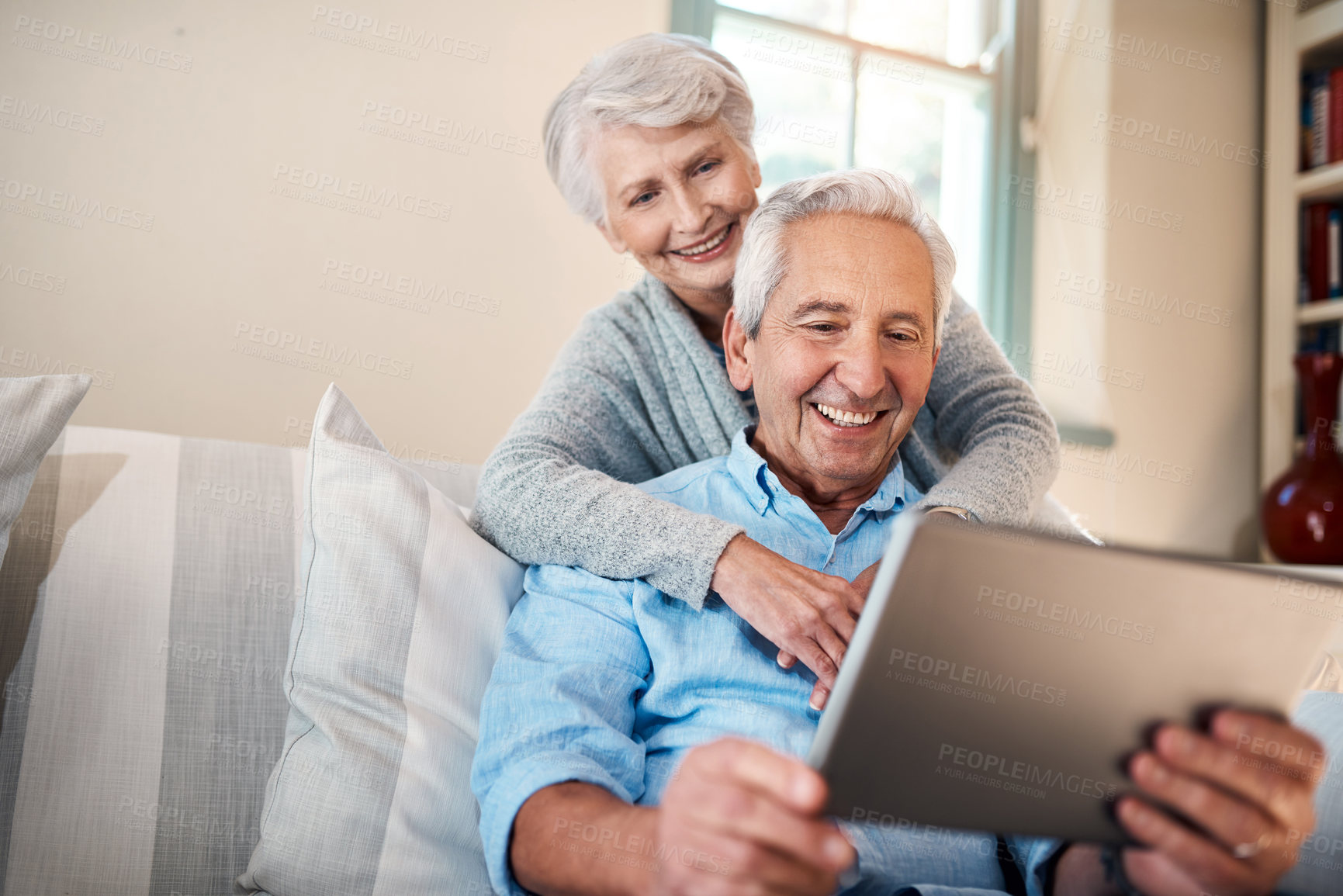 Buy stock photo Shot of a senior couple using a digital tablet together in their living room at home