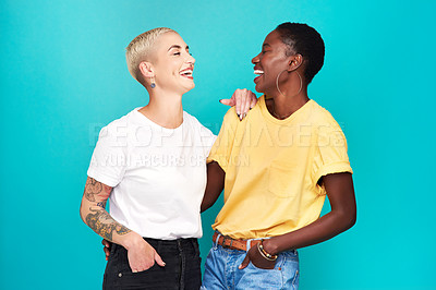 Buy stock photo Studio shot of two happy young women posing together against a turquoise background