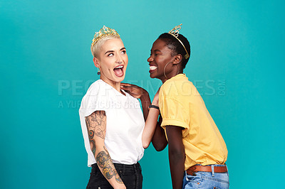 Buy stock photo Studio shot of two young women wearing crowns against a turquoise background