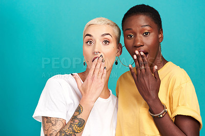 Buy stock photo Studio shot of two young women looking shocked against a turquoise background