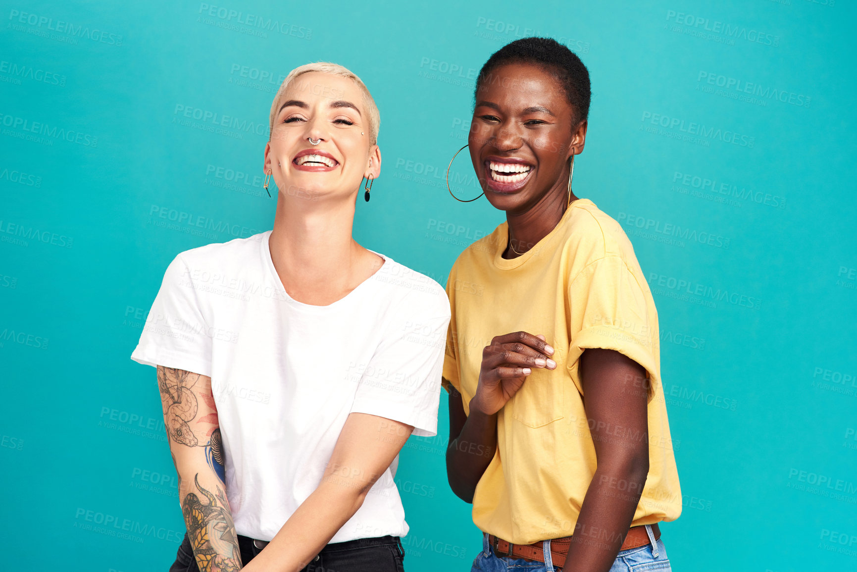 Buy stock photo Studio shot of two happy young women posing together against a turquoise background
