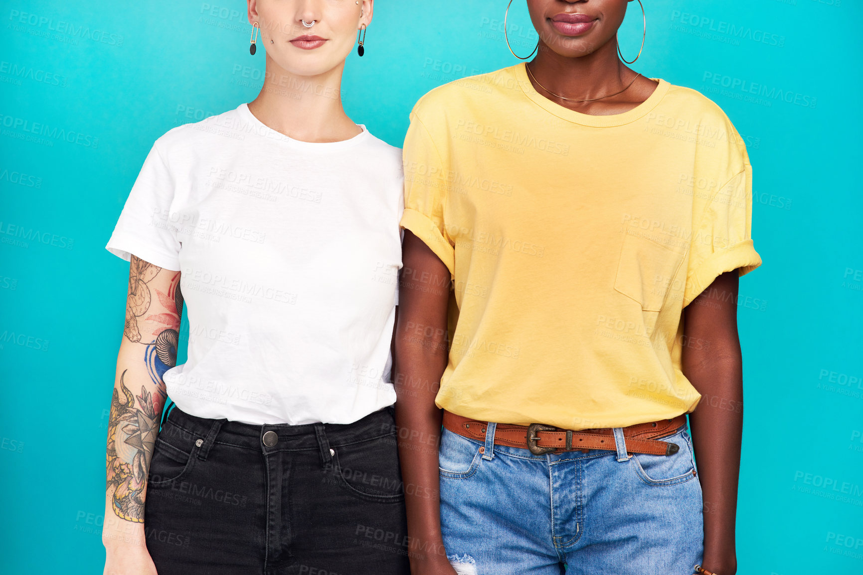 Buy stock photo Cropped studio shot of two young women standing together against a turquoise background