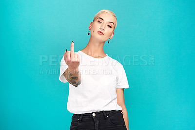Buy stock photo Studio shot of a young woman showing her middle finger against a turquoise background