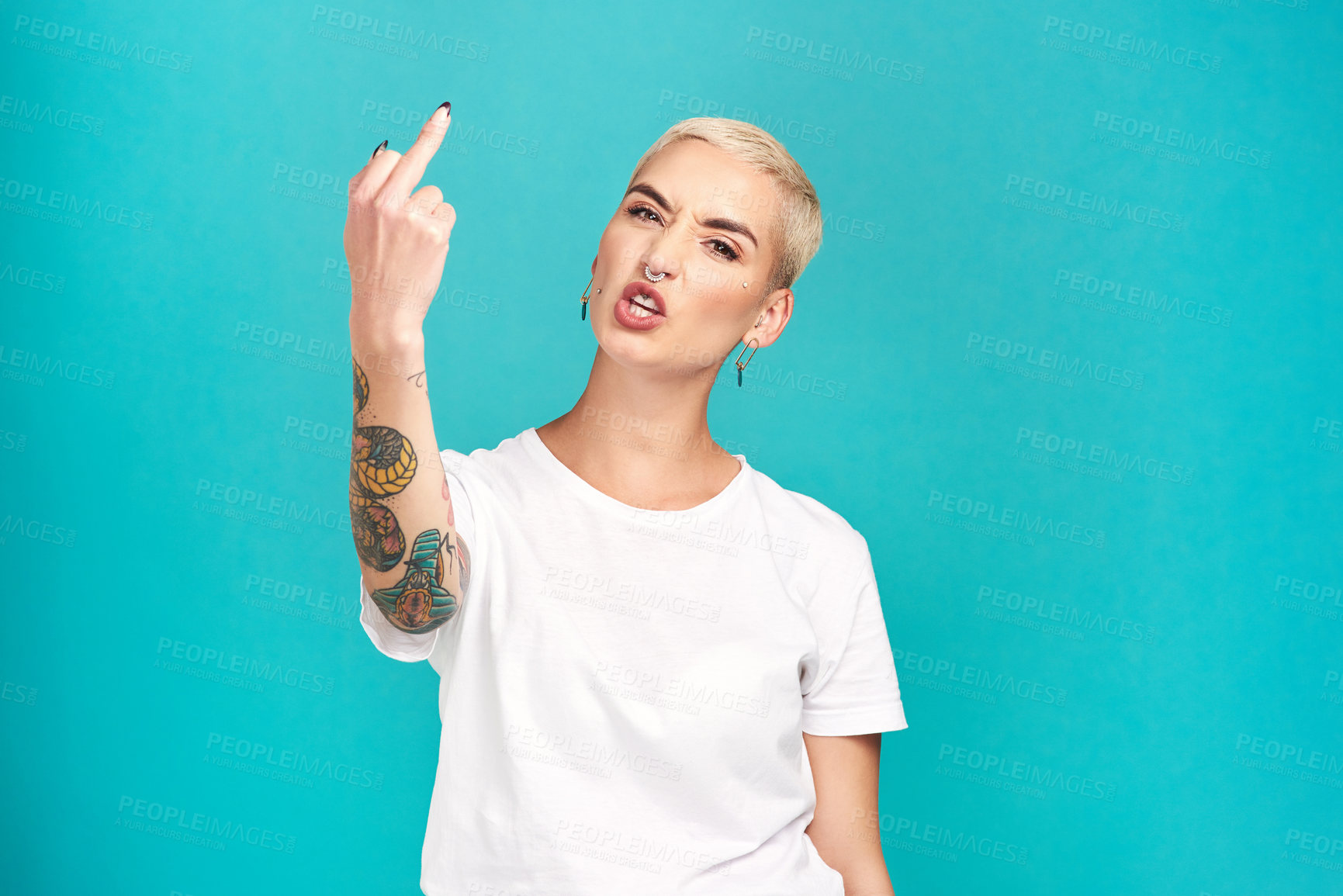 Buy stock photo Studio shot of a young woman showing her middle finger against a turquoise background