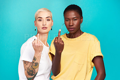 Buy stock photo Studio shot of two young women showing their middle fingers against a turquoise background