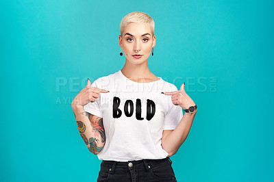 Buy stock photo Studio shot of a confident young woman wearing a t shirt with “bold” on it against a turquoise background