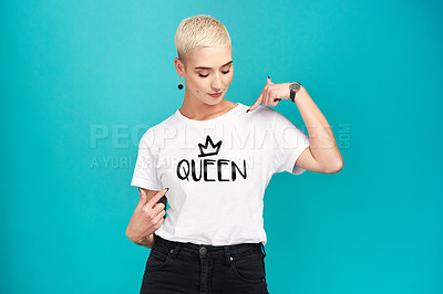 Buy stock photo Studio shot of a confident young woman wearing a t shirt with “queen” on it against a turquoise background
