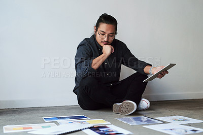 Buy stock photo Full length shot of a creative young businessman sitting on the floor and planning and brainstorming ideas at work