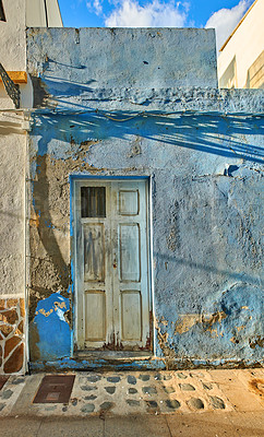 Buy stock photo Old and historic damaged wall with a door outdoors in the city of Santa Cruz de La Palma. An antique abandoned home or house built by vintage architecture with weathered peeling paint