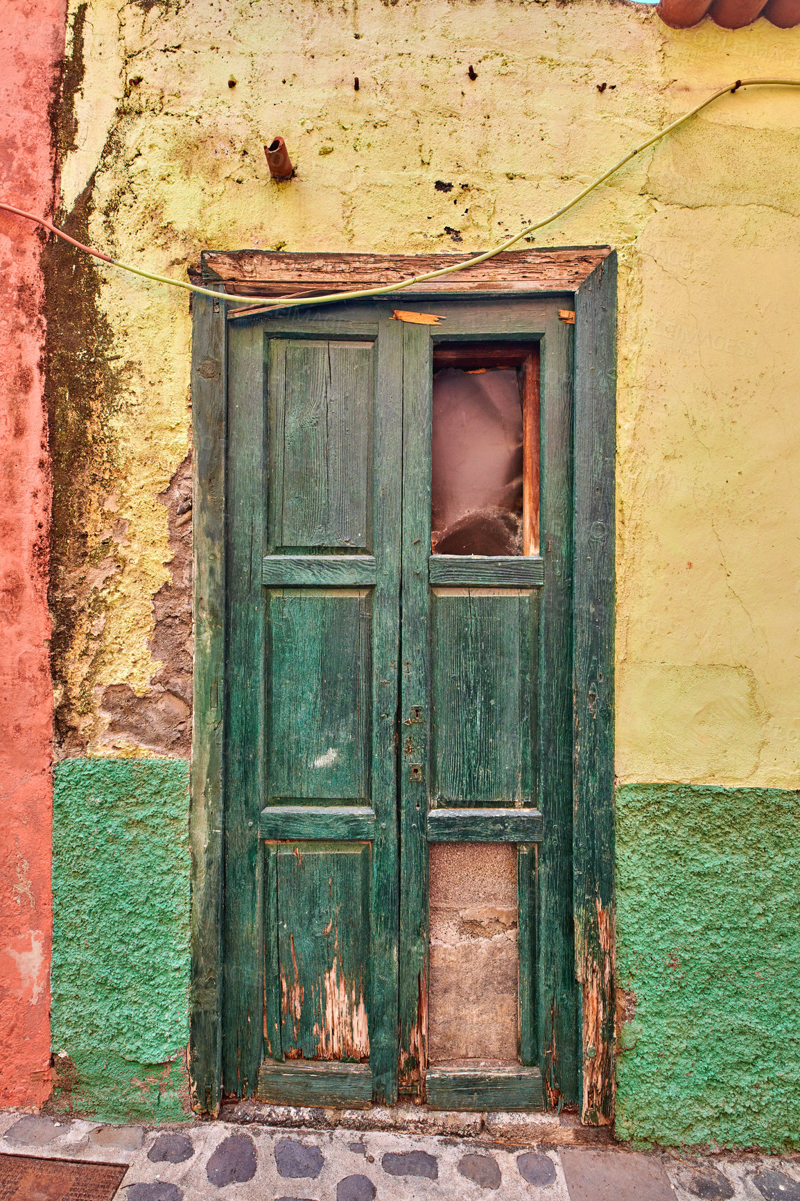 Buy stock photo Old damaged wooden door of an abandoned weathered building. Vintage broken and aged green entrance to a house in a small village or town on a sunny day. Antique and rustic doorway of a vacant home