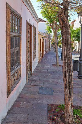 Buy stock photo City view paved sidewalk with trees and residential houses or buildings on a quiet street in Santa Cruz, La Palma, Spain. Historical spanish and colonial architecture and famous tourism destination 