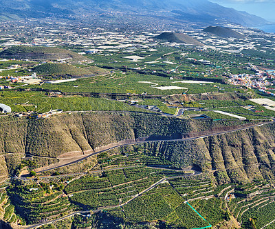 Buy stock photo Beautiful landscape of a small agricultural village on a sunny afternoon near a highway or busy road for logistics or transport of goods. Banana plantations in the town of Los Llanos, La Palma, Spain