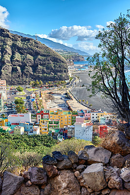 Buy stock photo Colorful town houses or holiday resort accommodation near the seaside in a beautiful tourism destination, La Palma, Spain. An ocean coast with black beach sand on Puerto de Tazacorte beach from above