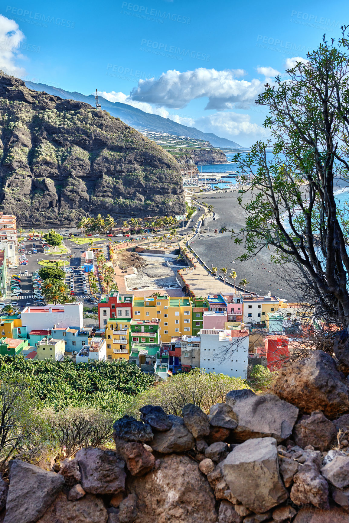 Buy stock photo Colorful town houses or holiday resort accommodation near the seaside in a beautiful tourism destination, La Palma, Spain. An ocean coast with black beach sand on Puerto de Tazacorte beach from above