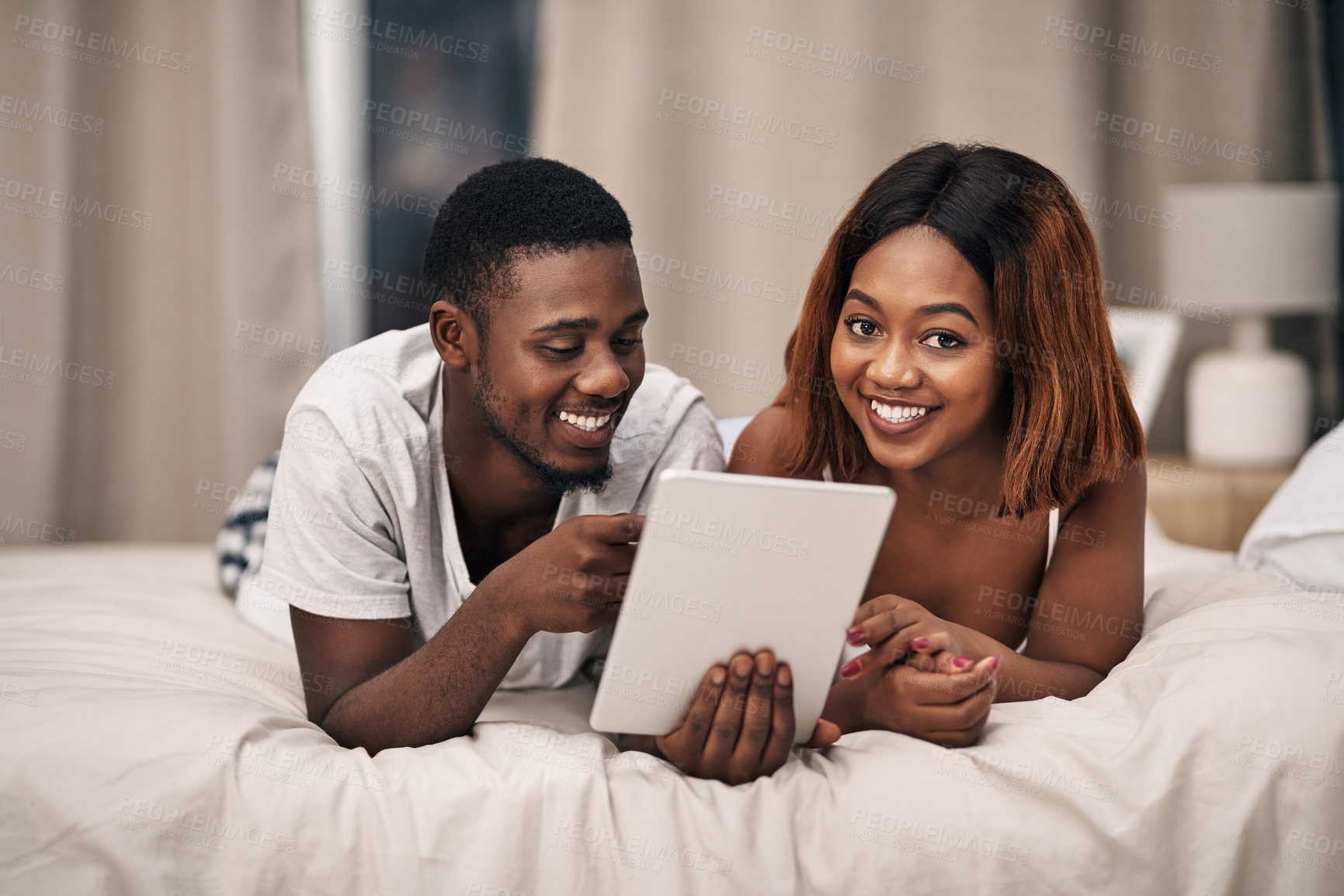 Buy stock photo Black couple, tablet and bed in home for relax entertainment or streaming movie for resting, bonding or subscription. Man, woman and online with digital app or comfortable day off, watching or film