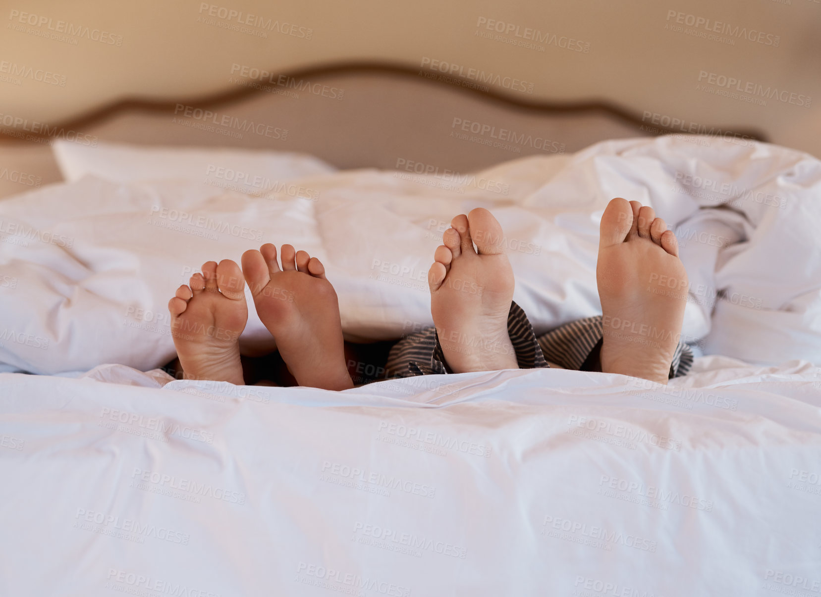 Buy stock photo Feet, relax and couple in bed at house with blanket for sleeping, resting and peace in nap together. Man, woman and duvet with love in bedroom at hotel for vacation, holiday and weekend trip
