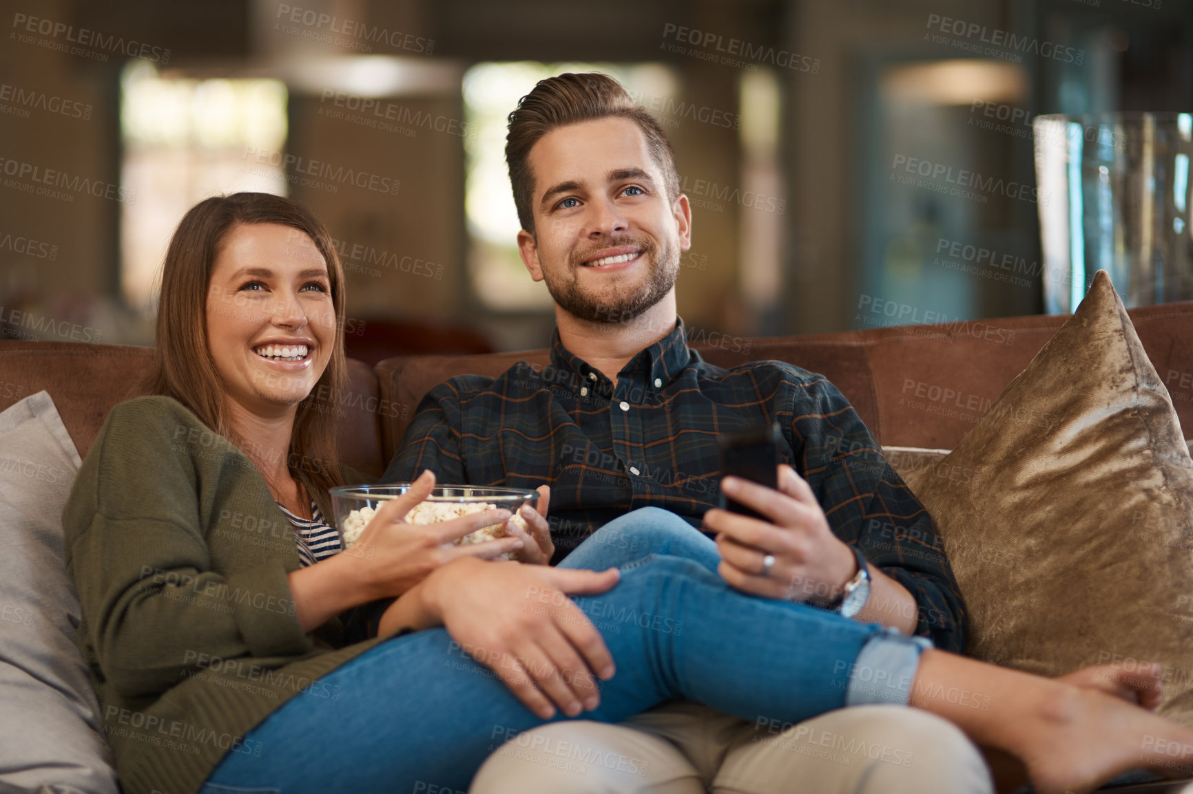 Buy stock photo Happy couple, smile and popcorn on sofa for movie, care or in love for relationship or dating on weekend in home. Man, woman and cheerful in house for bonding, relax or loving for watching tv
