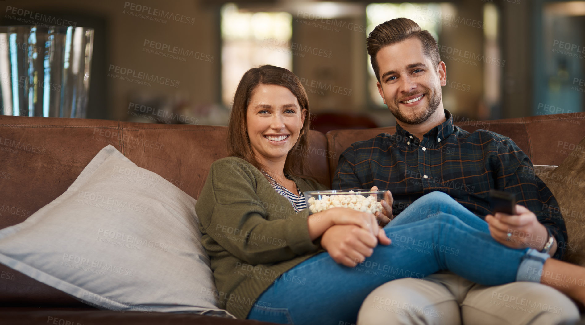 Buy stock photo Portrait, home and couple with popcorn, relax and series with happiness, smile and entertainment in lounge. Face, house or man with woman, love or streaming movie with snack or watching tv with break
