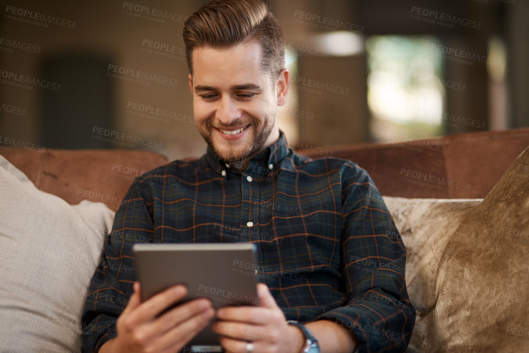 Buy stock photo Cropped shot of a young man relaxing on the sofa at home