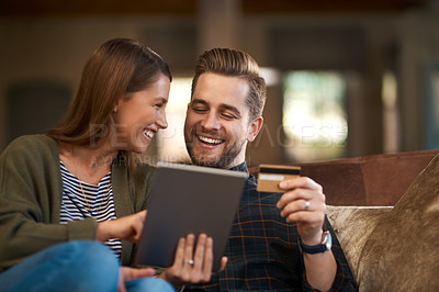 Buy stock photo Shot of a couple using a credit card while browsing on  a digital tablet