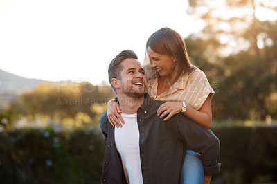 Buy stock photo Happy couple, hug and piggyback with love in nature for bonding, holiday or outdoor weekend together. Young man carrying woman with smile for embrace, journey or adventure outside in countryside