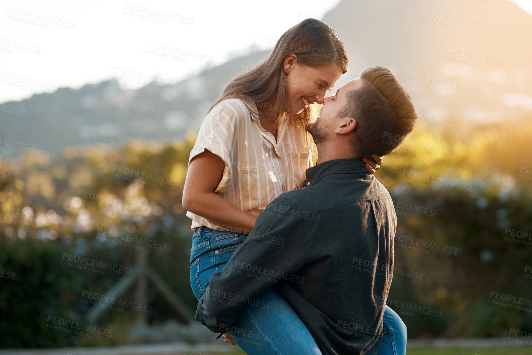 Buy stock photo Man, woman and carry with laughing in park for marriage anniversary or funny joke, love or romance. Happy couple, pick up and embrace in backyard for partnership travel on date, vacation or summer