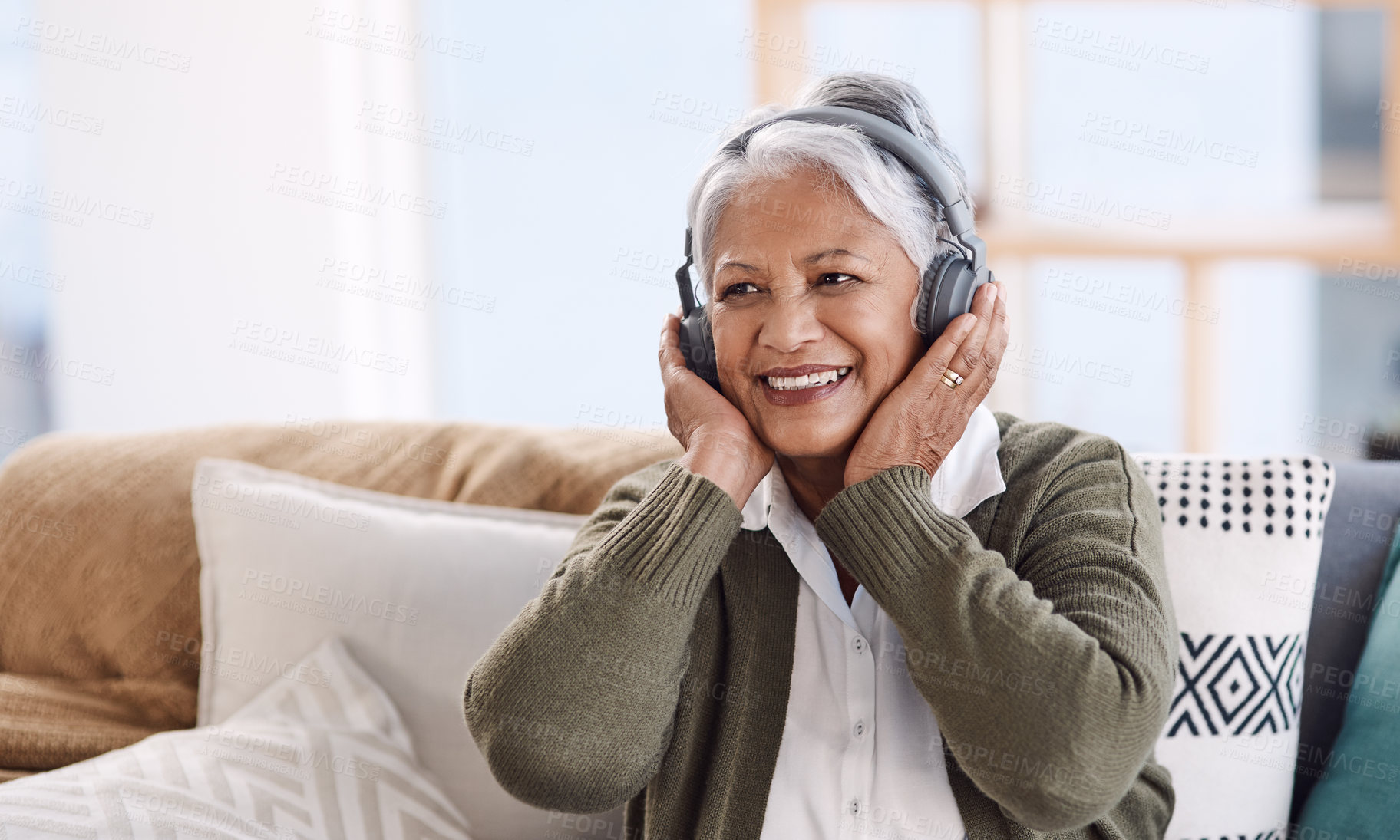 Buy stock photo Shot of a senior woman wearing headphones while listening to music at home