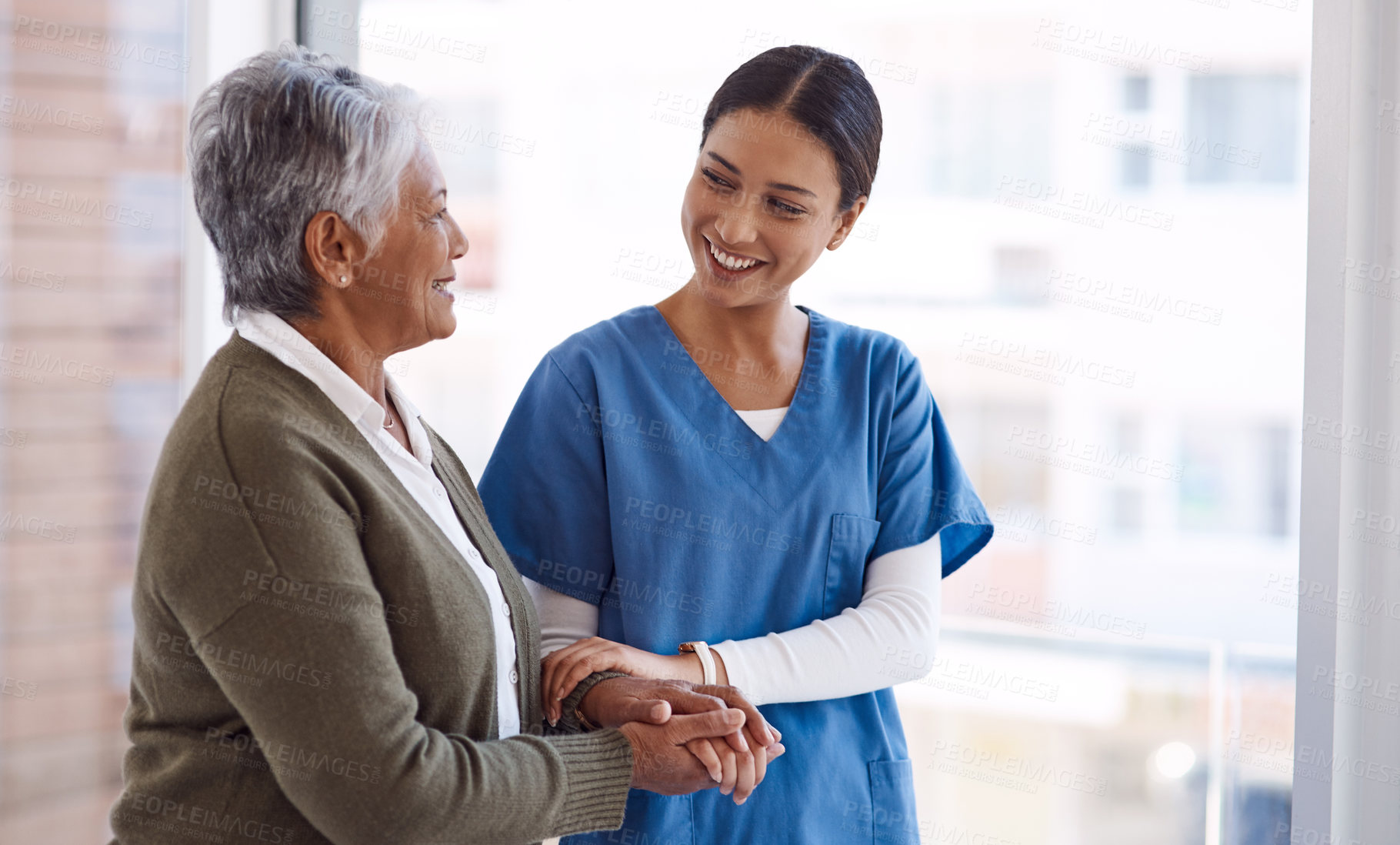 Buy stock photo Support, caregiver with senior woman and holding hands for care indoors. Retirement, consulting and professional female nurse with elderly person smiling together for healthcare at nursing home