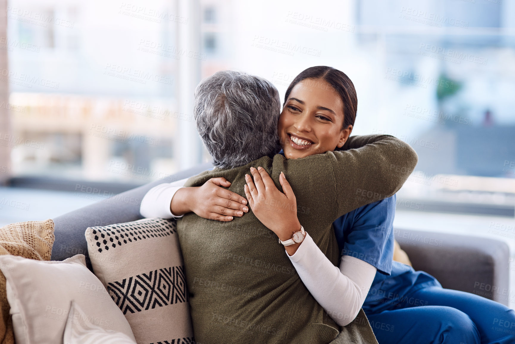 Buy stock photo Shot of a young nurse hugging a senior woman