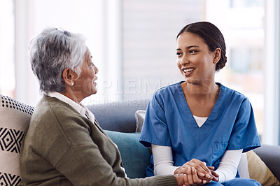 Buy stock photo Communication, caregiver and elderly woman on lounge holding hands in living room for support. Care or healthcare, happy people and female nurse talking or consulting with a patient on a sofa.