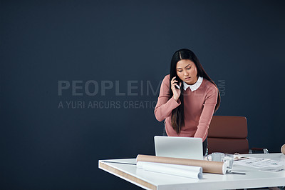 Buy stock photo Shot of an attractive young female architect making a phone call while working in her office
