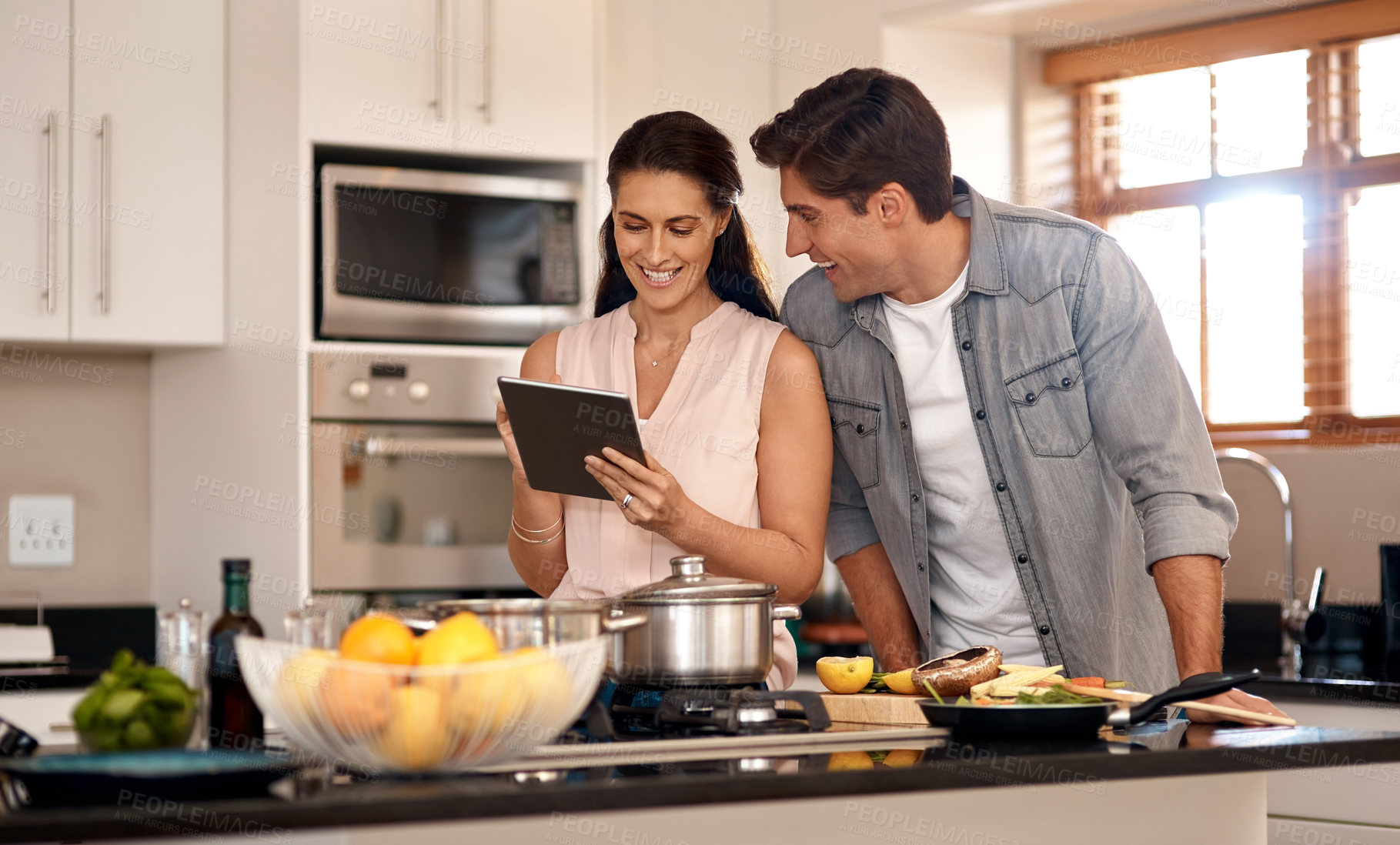 Buy stock photo Cropped shot of a young couple cooking together at home