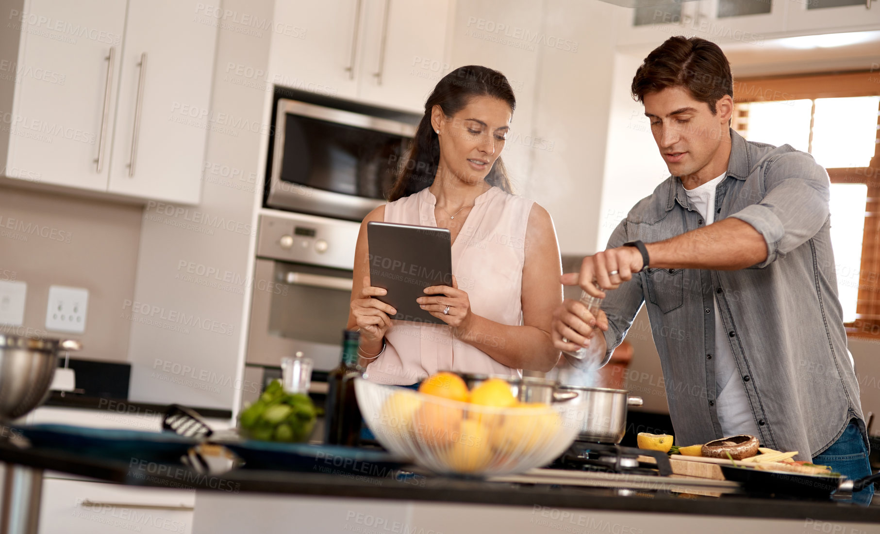 Buy stock photo Couple, cooking and tablet for recipe, kitchen and home with online, cheerful and making dinner. Food, digital and together with internet, family and nutrition while streaming, teaching and learn