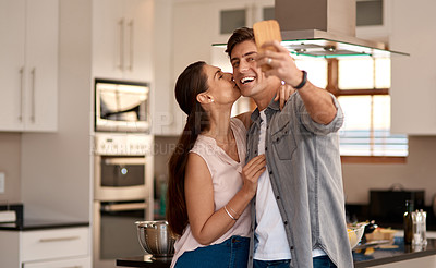Buy stock photo Shot of a loving couple taking a selfie together in the kitchen at home