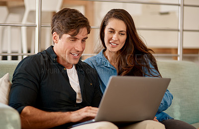 Buy stock photo Cropped shot of a couple using a laptop while relaxing together at home