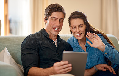 Buy stock photo Young couple, sofa and video call on tablet with wave, hello and smile for communication on internet app. Man, woman and happy for talking, chat or hello on social media, web and relax in home lounge