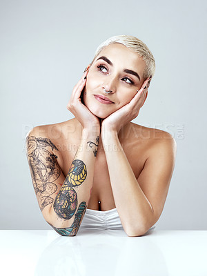 Buy stock photo Woman, thinking and tattoo with makeup in studio for beauty treatment, dermatology and facial glow. Person, relax and body art with confidence for cosmetics, shine or satisfaction on white background