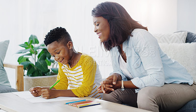 Buy stock photo Shot of a mother helping her young son with his homework at home