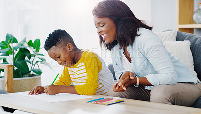 Buy stock photo Shot of a mother helping her young son with his homework at home