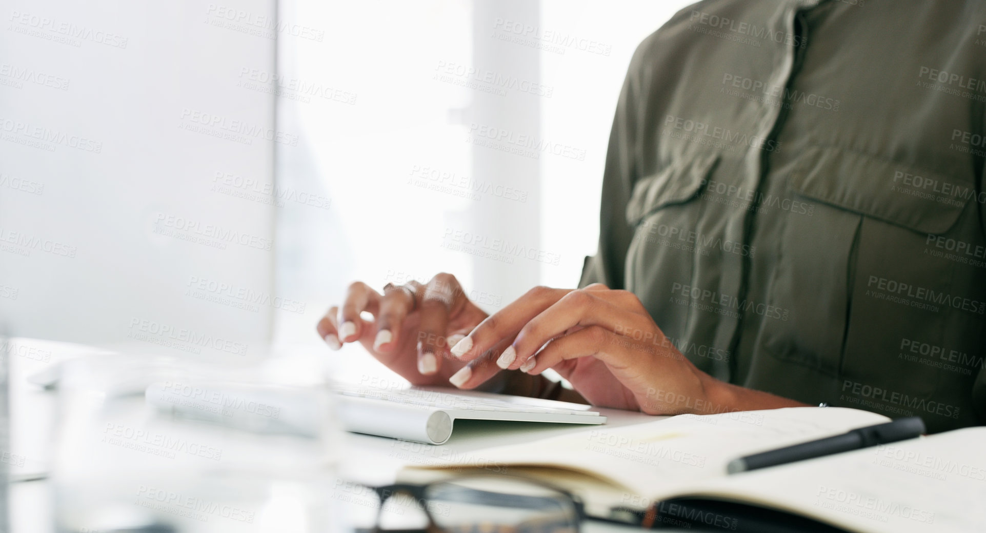 Buy stock photo Cropped shot of businesswoman using a computer at her desk in a modern office