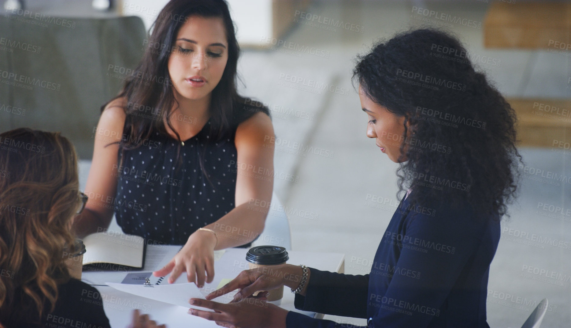 Buy stock photo High angle shot of three young businesswoman sitting in the boardroom during a management meeting