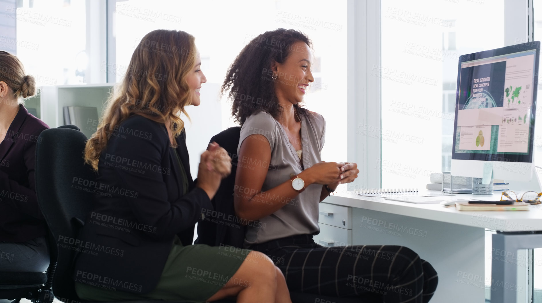 Buy stock photo Shot of two young businesswomen using a computer together in a modern office