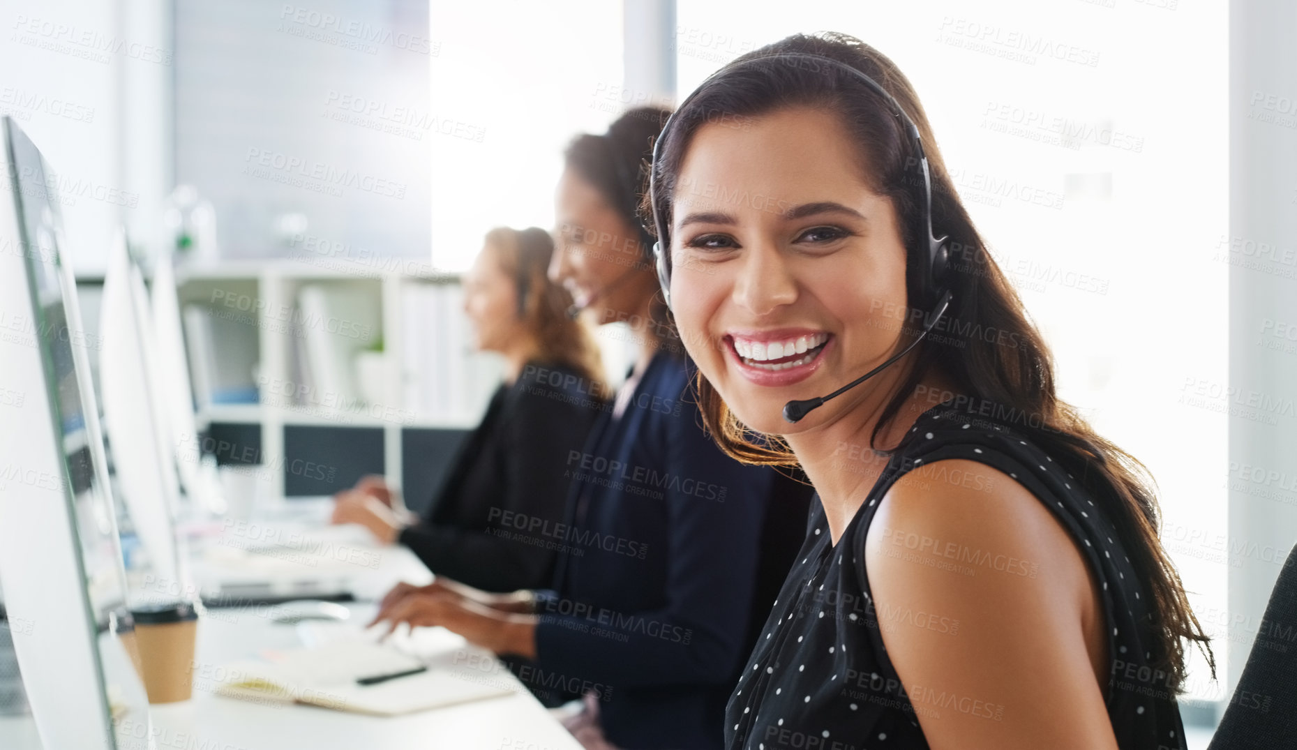 Buy stock photo Shot of a young woman using a computer and headset in a modern office