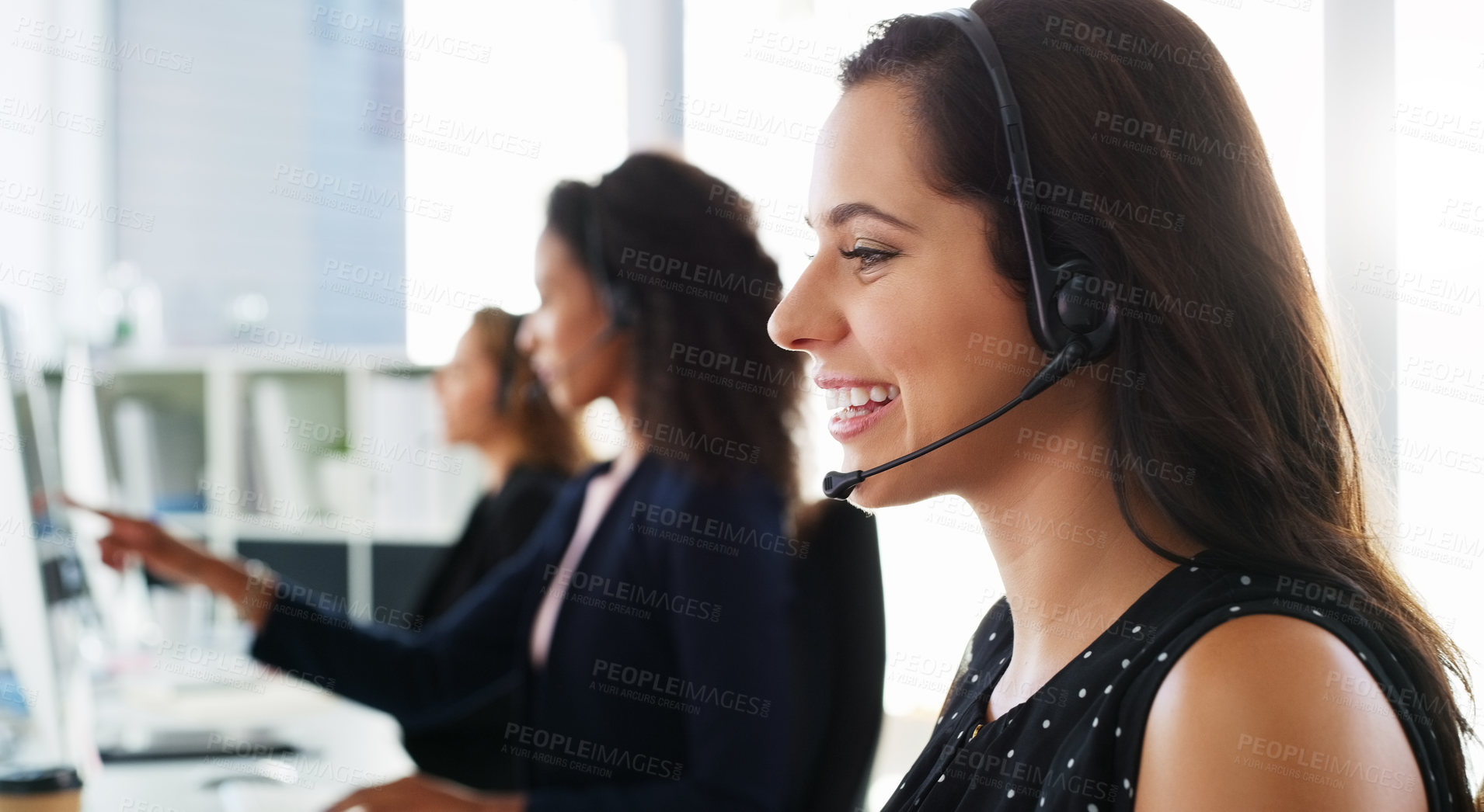 Buy stock photo Shot of a young woman using a computer and headset in a modern office