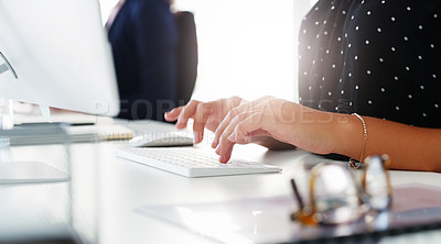 Buy stock photo Cropped shot of businesswoman using a computer at her desk in a modern office