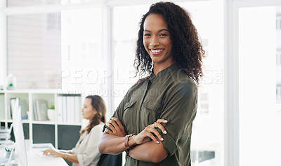Buy stock photo Portrait of a confident young businesswoman working in a modern office with her colleague in the background